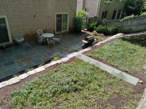 Stylish backyard patio with seating area and garden beds, perfect for outdoor gatherings and relaxation.