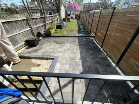Clean backyard with paver patio and wooden privacy fence, landscape prep for outdoor living.