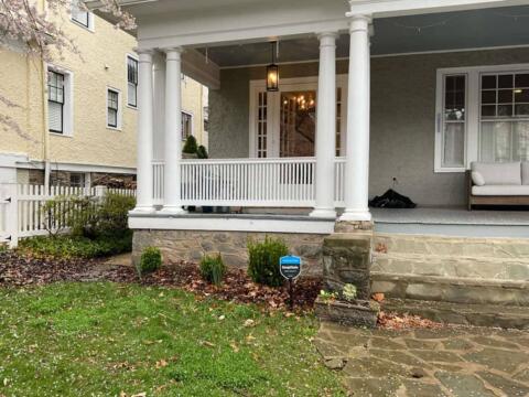 Elegant porch with white columns and railing at Tenleytown Lawn & Landscape.